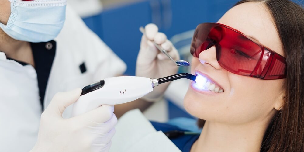 Female patient receiving painless laser dental treatment during a routine dentist visit.
