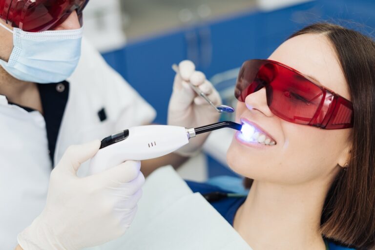 Female patient receiving painless laser dental treatment during a routine dentist visit.